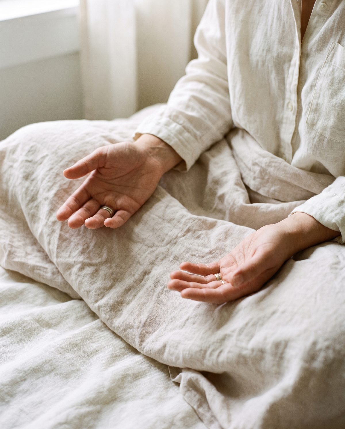 A person seated calmly in meditation with open hands resting on the lap